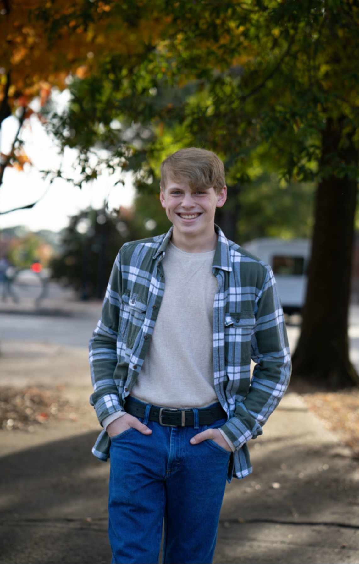 Image of Christopher Garrison in an open button-up shirt and jeans with a belt