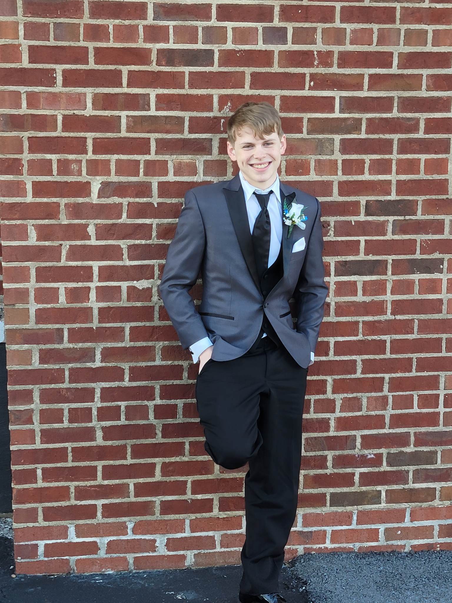 Image of Christopher Garrison in a suit standing infront of a brick wall